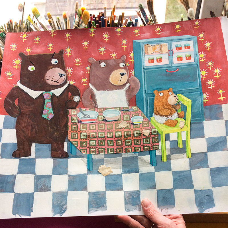 a photograph of a piece of artwork of bears in a kitchen in a children's book style, against a backdrop of an artist's desk