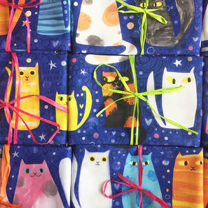 folded tea towels with cat illustrations  by Jo Brown tied with ribbon