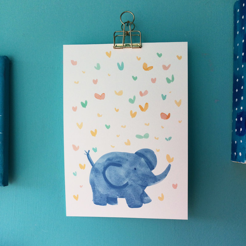 A print of an illustration of a baby elephant with butteries hanging by a gold clip amongst other paintings