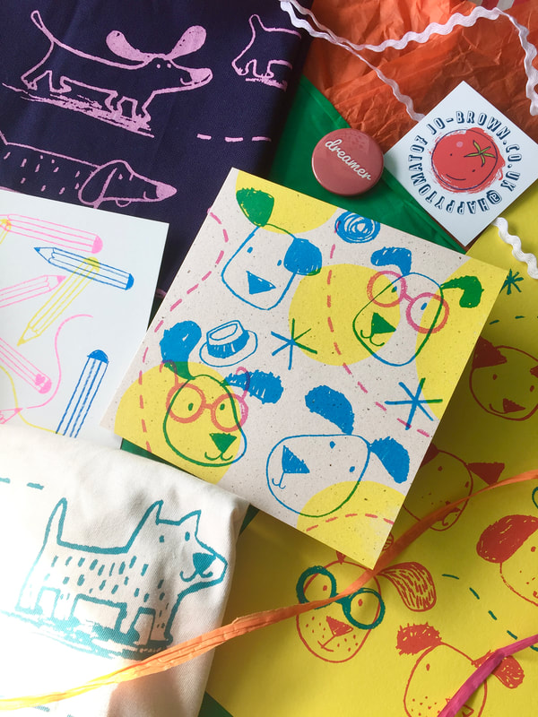 close up of various printed items featuring dog illustrations on paper and fabric by Jo Brown